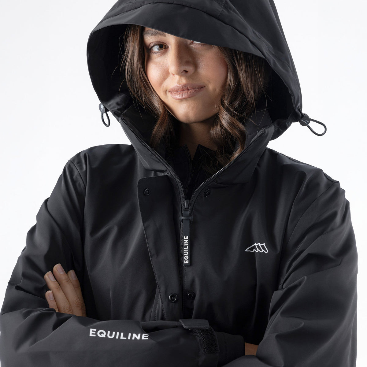Equiline Ladies Eqextre black waterproof jacket worn with the adjustable hood up, showing the taped-seam water-tight construction.