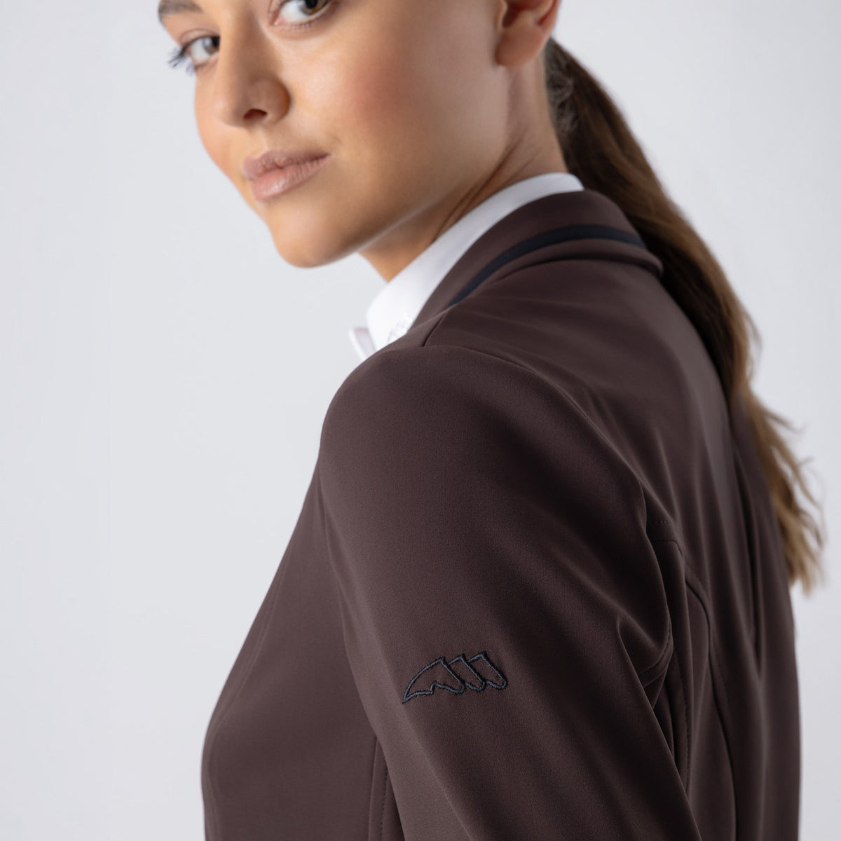 Equiline Ladies Eqjacky coffee bean show jacket detail, showing the embroidered Equiline logo on the shoulder and breathable stretch fabric.