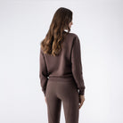 Equiline Ladies Eqzzie cocoa powder crewneck sweatshirt, rear view showing the ribbed hem and embroidered sleeve logo.
